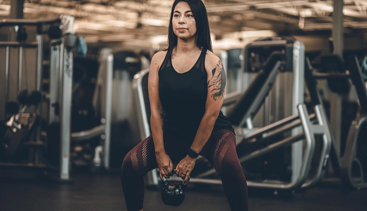 woman performing a kettlebell squat