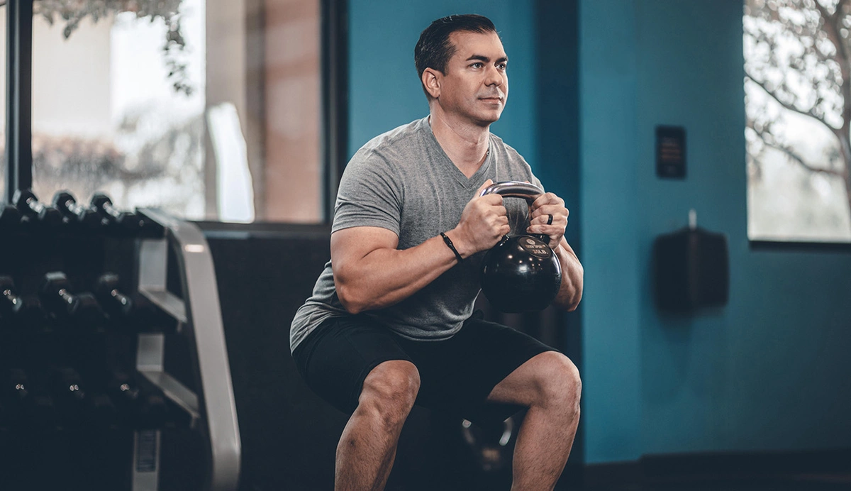 Man performing a kettlebell squat